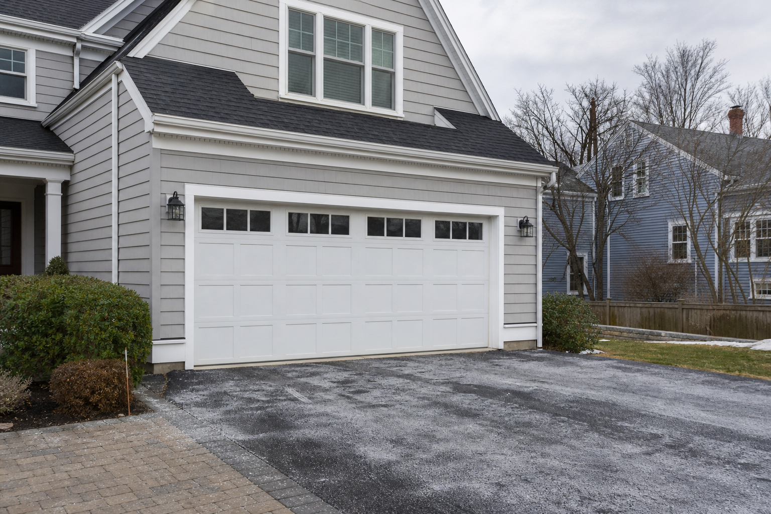 Newton home exterior with a closed garage door on an overcast day